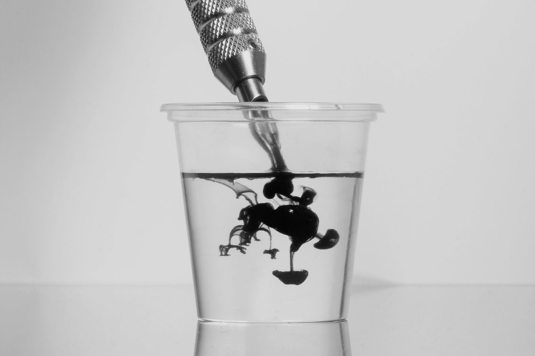 Ink dispersing in a cup of water